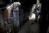 FILE - In this May 5, 2020 file photo, a dog stands on a staircase where a worker disinfects the streets of the "Villa 31" neighborhood during a government-ordered lockdown to curb the spread of the new coronavirus in Buenos Aires, Argentina. Argentina reached 1 million confirmed coronavirus cases on Monday, Oct. 19, 2020, according to the Ministry of Health. (AP Photo/Natacha Pisarenko, File)