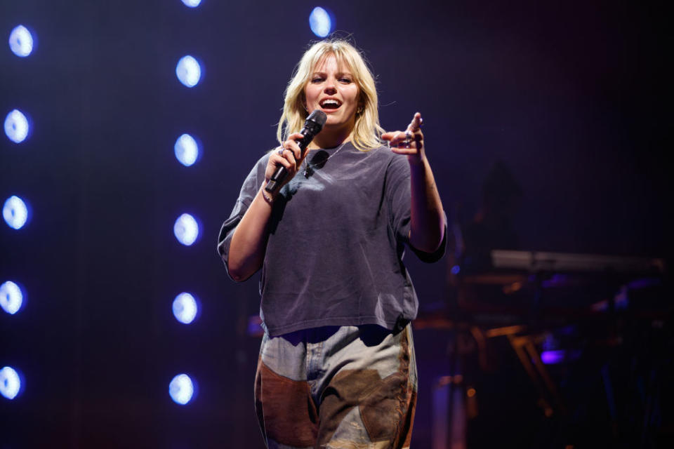 Renee performing on stage with a microphone