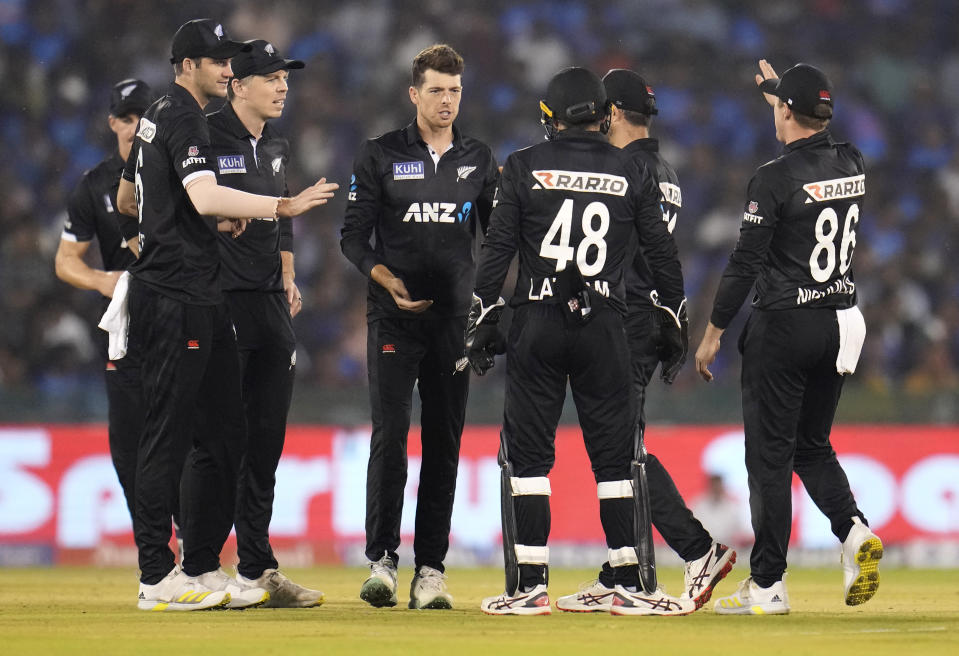 New Zealand's Mitchell Santner, center without cap, celebrates with teammates after the dismissal of India's Virat Kohli during the second one-day international cricket match between India and New Zealand in Raipur, India, Saturday, Jan. 21, 2023. (AP Photo/Aijaz Rahi)