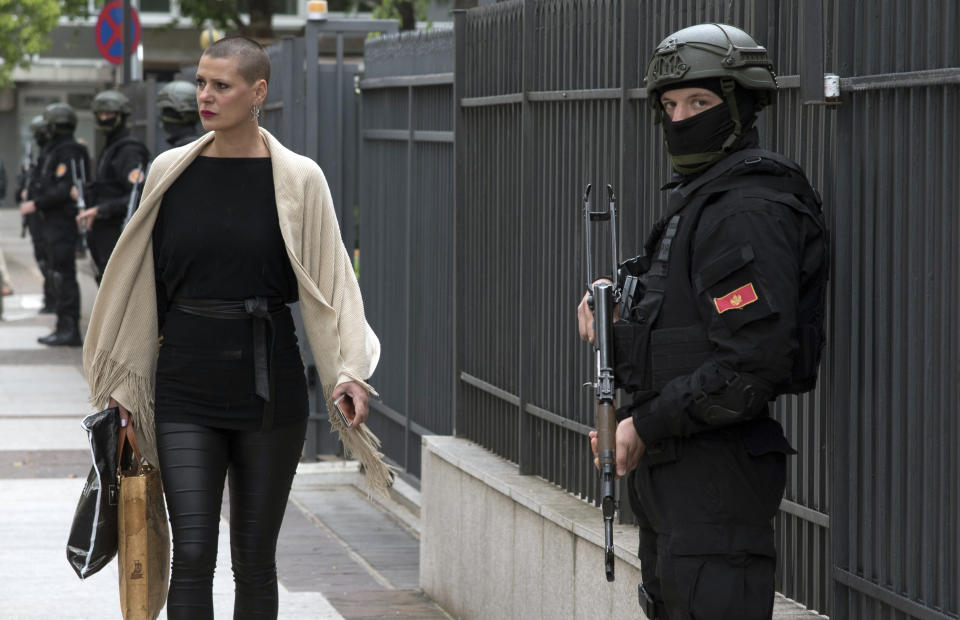 Montenegro police officers guard the entrance to the court building during the verdict in the case of ''attempted terrorism'' and ''creating a criminal organization'', in Podgorica, Montenegro, Thursday, May 9, 2019. A court in Montenegro has sentenced 13 people, including two Russian secret service operatives, to up to 15 years in prison after they were found guilty of plotting to overthrow the Balkan country's government and prevent it from joining NATO. (AP Photo/Risto Bozovic)