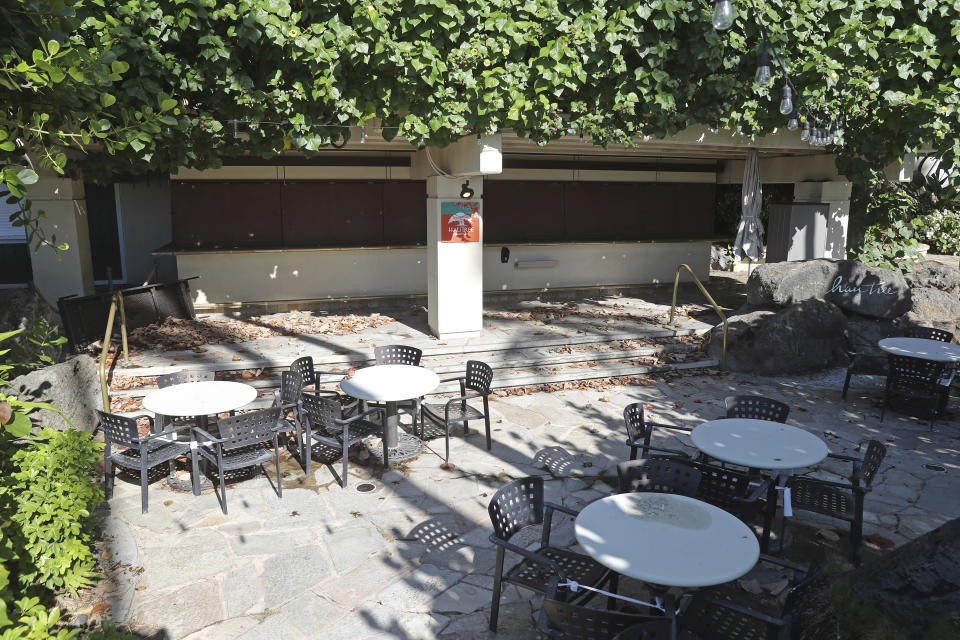 A shuttered outdoor restaurant is viewed in a popular resort in Waikiki, Thursday, Oct. 15, 2020, in Honolulu. A new pre-travel testing program will allow visitors who test negative for COVID-19 to come to Hawaii and avoid two weeks of mandatory quarantine goes into effect Thursday. The pandemic has caused a devastating downturn on Hawaii's tourism-based economy and many are hoping the testing will help the economy rebound. (AP Photo/Marco Garcia)