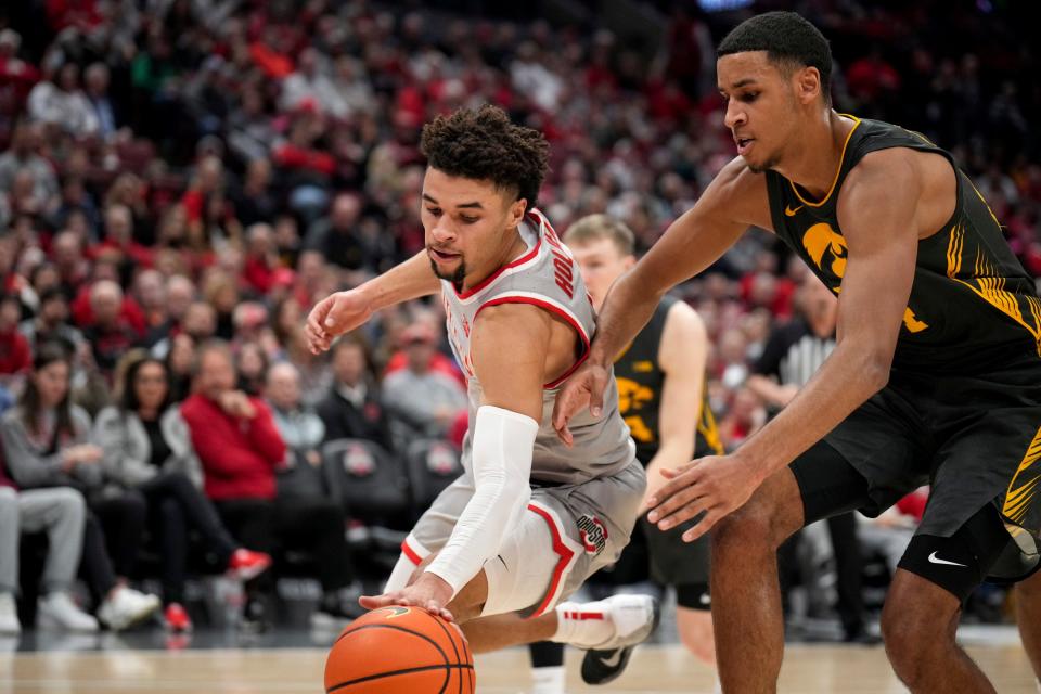 Ohio State guard Tanner Holden fights for control of the ball with Iowa forward Kris Murray.