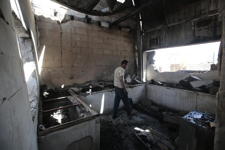 A worker inspects the damage to a plastic materials factory destroyed by Saudi-led airstrikes, in Sanaa, Yemen, Tuesday, Nov. 23, 2021. (AP Photo/Hani Mohammed)