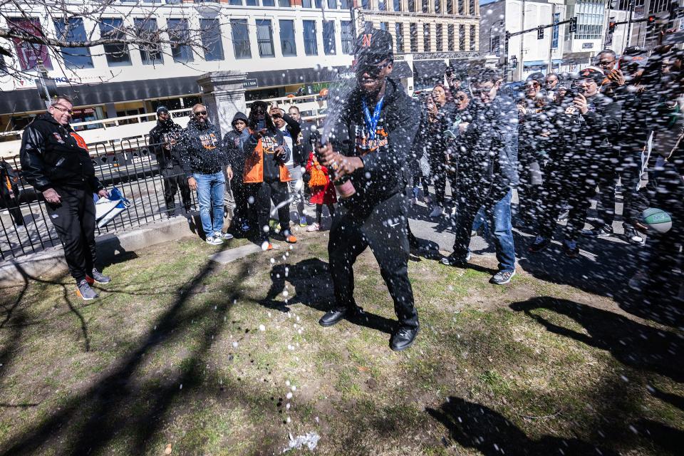 North High senior boys' basketball captain Joe Okla sprays sparkling cider during the championship rolling rally and parade.