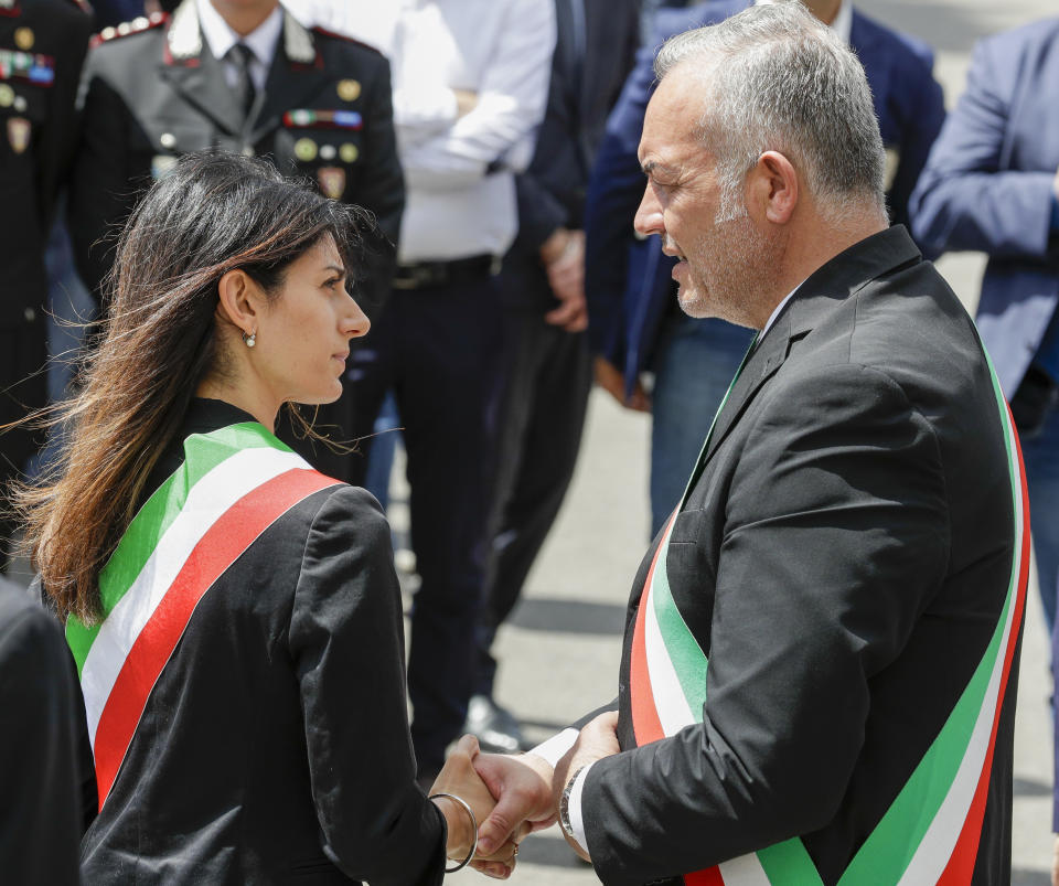 Rome's Mayor Virginia Raggi, left, and Somma Vesuviana mayor Salvatore Di Sarno talk as they wait the start of the funeral for Carabinieri's officer Mario Cerciello Rega in his hometown of Somma Vesuviana, near Naples, southern Italy, Monday, July 29, 2019. Two American teenagers were jailed in Rome on Saturday as authorities investigate their alleged roles in the fatal stabbing of the Italian police officer on a street near their hotel. (AP Photo/Andrew Medichini)