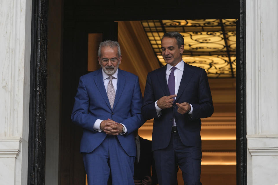 Greece's Prime Minister Kyriakos Mitsotakis, right, talks to caretaker Prime Minister Ioannis Sarmas at the end of a handover ceremony at Maximos mansion, in Athens, Greece, Monday, June 26, 2023. Greece's conservative New Democracy party leader Kyriakos Mitsotakis has vowed to speed up reforms following his landslide victory in the country's second election in five weeks. (AP Photo/Petros Giannakouris)