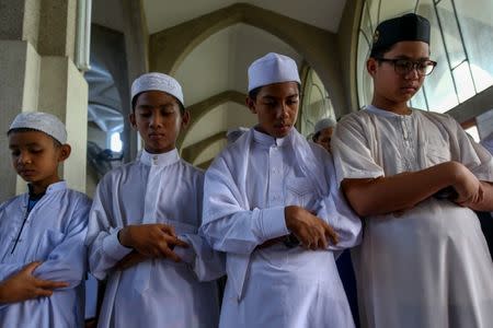 Muslims attend an Eid al-Fitr mass prayer to mark the end of the holy fasting month of Ramadan at a mosque in Bangkok, Thailand, June 25, 2017. REUTERS/Athit Perawongmetha