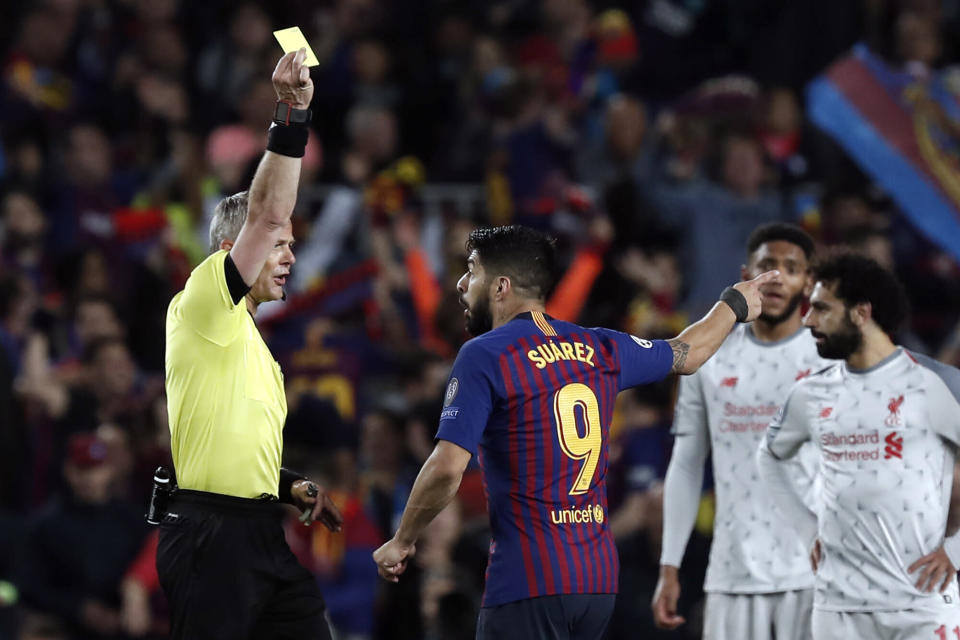 Referee Bjorn Kuipers shows a yellow card to Barcelona's Luis Suarez during the Champions League semifinal, first leg, soccer match between FC Barcelona and Liverpool at the Camp Nou stadium in Barcelona Spain, Wednesday, May 1, 2019. (AP Photo/Joan Monfort)