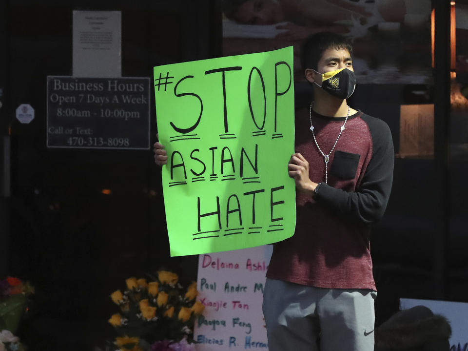 Jesus Estrella, of Kennesaw, Ga., stands outside Youngs Asian Massage on Wednesday, March 17, 2021, in Acworth, Ga., where four people were fatally shot Tuesday. A white gunman was charged Wednesday with killing eight people at three Atlanta-area massage parlors in an attack that sent terror through the Asian American community, which has increasingly been targeted during the coronavirus pandemic. Estrella, who is of Asian and Hispanic descent, said, "I felt I had to come and support the community." (Curtis Compton/Atlanta Journal-Constitution via AP)