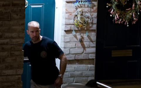 An agent with the Bureau of Alcohol, Tobacco, Firearms and Explosives leaves the family home of the suspected shooter - Credit: Jose Luis Magana/AP