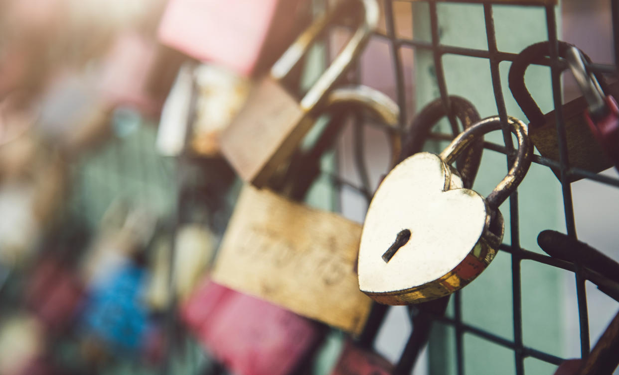 Close up shot of a heart shaped padlock of love locked on a railing of a bridge. Shot in Hamburg, Germany