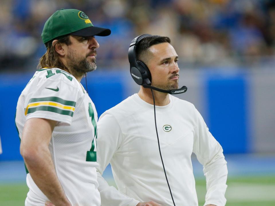 Aaron Rodgers and Matt LaFleur watch from the sidelines during a game against the Detroit Lions.