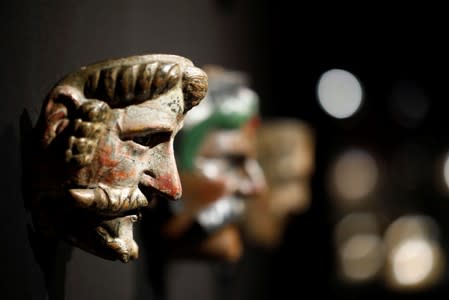 A dancing mask with a man's head and a large moustache, one of pre-Columbian artefacts, is presented to the press at Drouot auction house in Paris