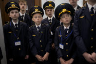 Children in train guard uniforms wait for the departure of a children's train in Kyiv, Ukraine, Saturday, June 4, 2022. The Children's Railways, that lets children drive trains and learn about working the railways, started to run again Saturday around the Syretskyi Park rail track after being closed due to the war with Russia. (AP Photo/Natacha Pisarenko)