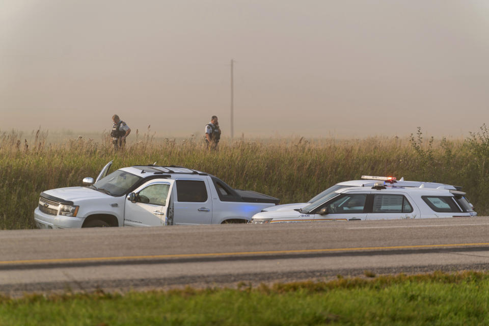 Police and investigators gather at the scene where a stabbing suspect was arrested in Rosthern, Saskatchewan on Wednesday, Sept. 7, 2022. Canadian police arrested Myles Sanderson, the second suspect in the stabbing deaths of multiple people in Saskatchewan, after a three-day manhunt that also yielded the body of his brother fellow suspect, Damien Sanderson.(Heywood Yu/The Canadian Press via AP)