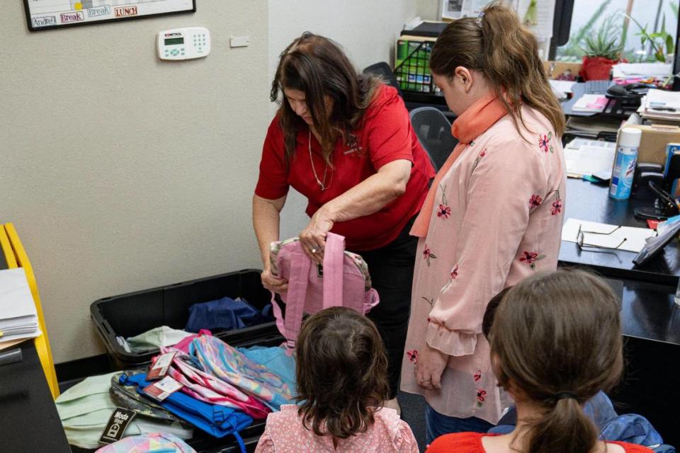 Cynthia Corral, center, distributes backpacks to refugee children at the Asian Resources Community Services offices Wednesday in Citrus Heights. Kevin Neri/kneri@sacbee.com