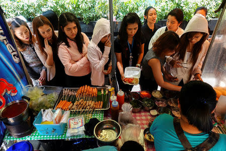 People queue to buy their lunch at a street food shop in Bangkok, Thailand April 20, 2017. REUTERS/Athit Perawongmetha