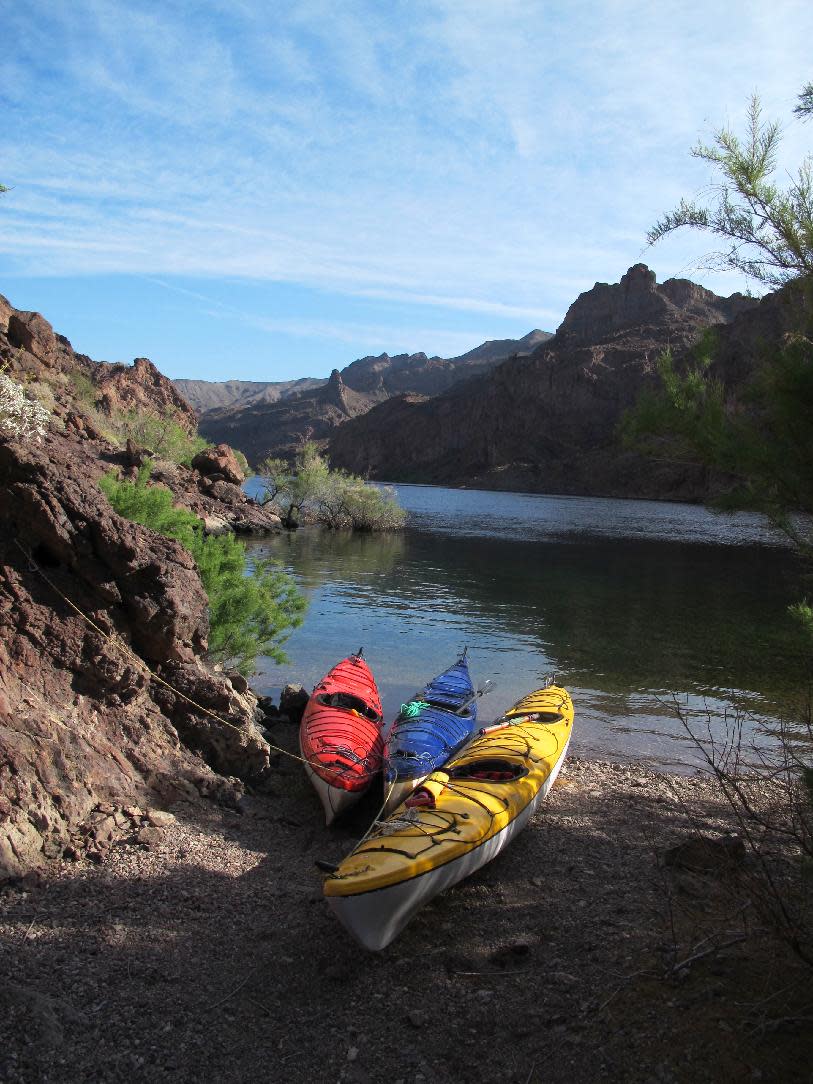 This April 13, 2013 photo shows kayaks pulled up on the shore of the Colorado River in Nevada. Outfitters can pick you up at a hotel in Las Vegas first thing in the morning and have you paddling the river through the Black Canyon some 30 miles from Las Vegas before lunch. The put-in area is near the Hoover Dam, a federal security zone, so watercraft must be transported by an authorized livery service, whether you bring your own gear, rent boats or sign up for a guided trip. (AP Photo/Karen Schwartz)