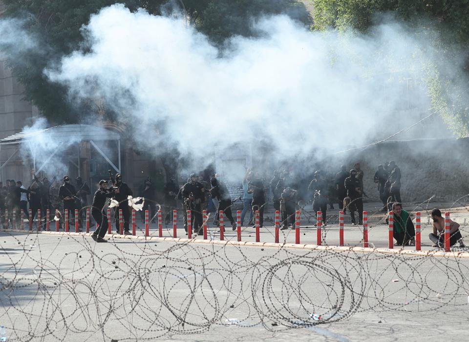 Iraqi security forces fire tear gas to disperse anti-government protesters during a demonstration in central Baghdad, Iraq, Friday, Oct. 25, 2019. Iraqi police are firing tear gas to disperse thousands of protesters in Baghdad where planned anti-government demonstrations have resumed after a three-week hiatus. (AP Photo/Hadi Mizban)