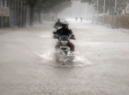 A man rides his motorbike through a flooded road during heavy rain in Chennai, India, November 9, 2015. REUTERS/Stringer
