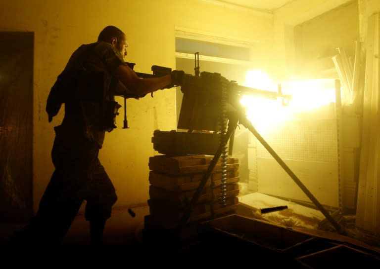 A Ukrainian soldier fires a heavy machine gun during a battle with pro-Russian separatists at Avdeyevka, in Ukraine's Donetsk region on June 25, 2016