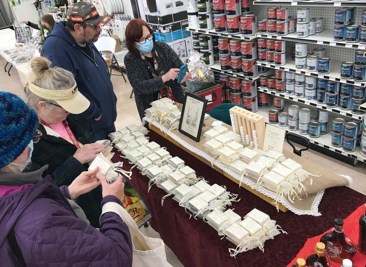 Elizabeth Comerford, right, chats with customers Dec. 4 at her Brown and Launt Soap Co. table at Parry's Indoor Farmers Market in Hamilton. The market returns the first and third Saturday of the month through April, except for Jan. 1.
