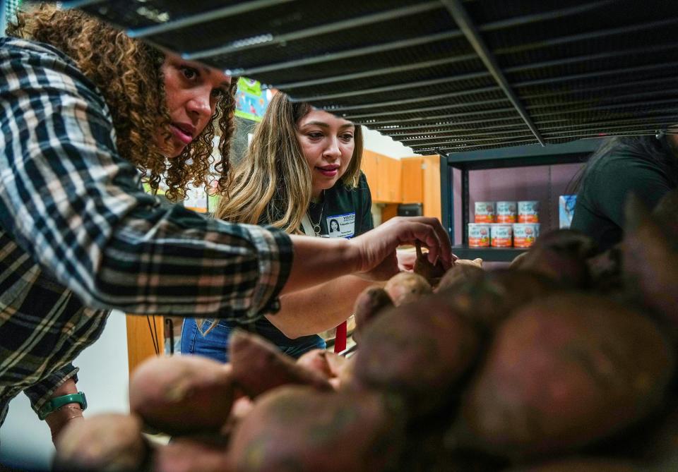 Social worker Kierten Hazelwood, left, helps Yaquelin Cornejo select food from the Creedmoor pantry. Among Cornejo's choices were some items she usually skips because price and novelty make her hesitant to try them.