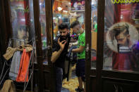 A man talks to a costumer as he stands inside his barber shop in the Old City of Damascus, Syria, September 13, 2018. REUTERS/Marko Djurica/Files