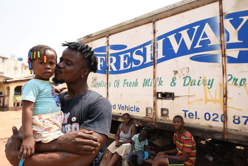 Yousef Kamara holds his daughter Stylvia in Freetown