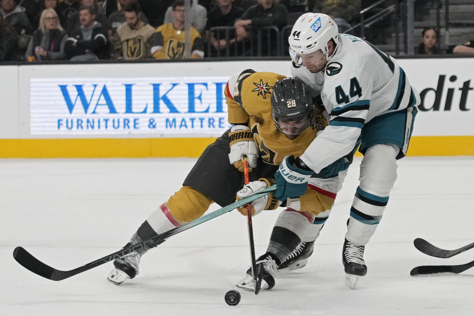 Vegas Golden Knights left wing William Carrier (28) vies for the puck with San Jose Sharks defenseman Marc-Edouard Vlasic (44) during the second period of an NHL hockey game Friday, Nov. 10, 2023, in Las Vegas. (AP Photo/John Locher)