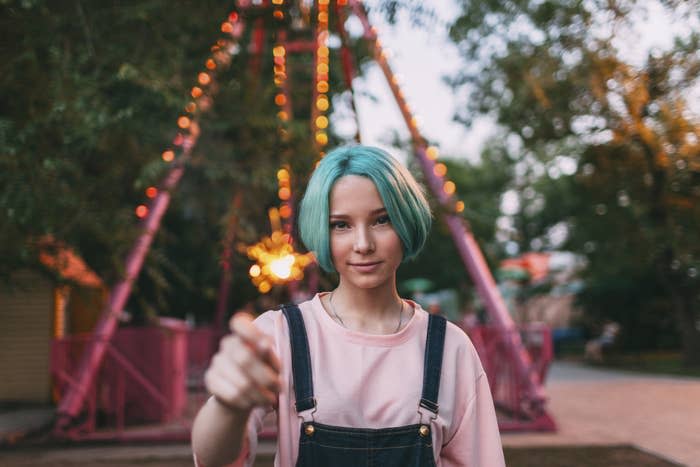 Portrait of smiling teenage girl holding illuminated sparkler