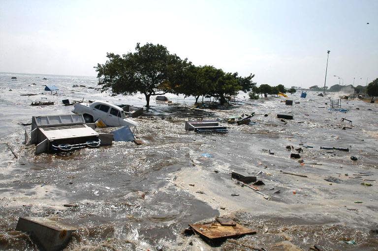 Cars and parts of buildings churn in the surf on Marina beach in Madras, India, on December 26, 2004, as tidal waves hit the coast