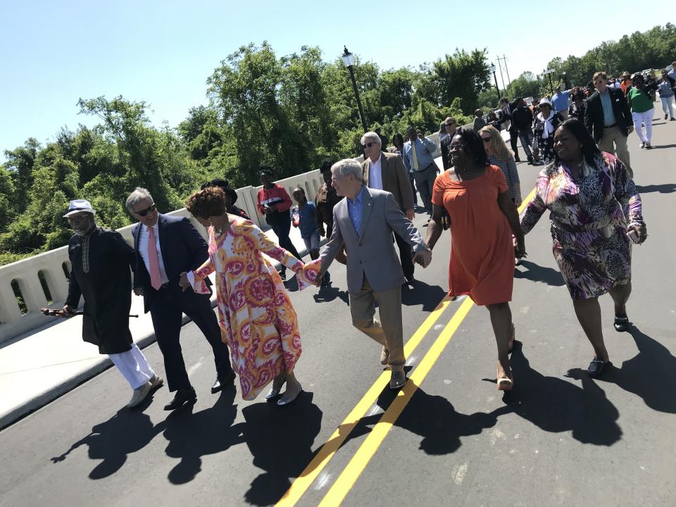 In 2018, Ron Sparks (left to right), Wilmington Mayor Bill Saffo, Lynda Smiley McMillan and Councilman Kevin O'Grady join hands with others to take the inaugural walk across the new Love Grove Memorial Bridge.