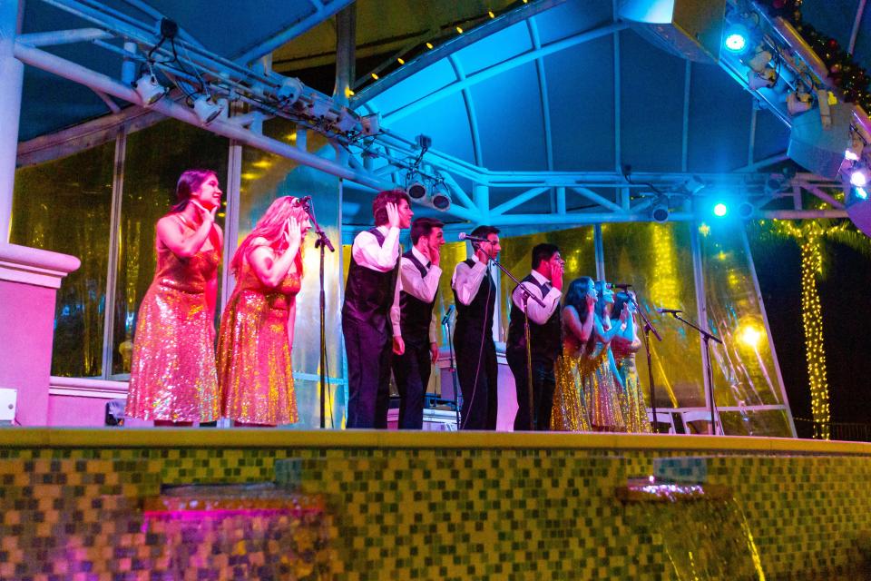 A crowd watches members of the Jupiter High School Choir perform holiday jingles in front of the fountain at the Harbourside Place Amphitheater in 2019.