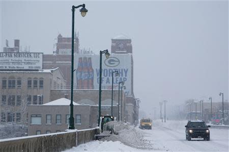 A city employee clears a sidewalk, as a winter storm moves across the midwest, in Milwaukee, Wisconsin December, 22, 2013. REUTERS/Darren Hauck