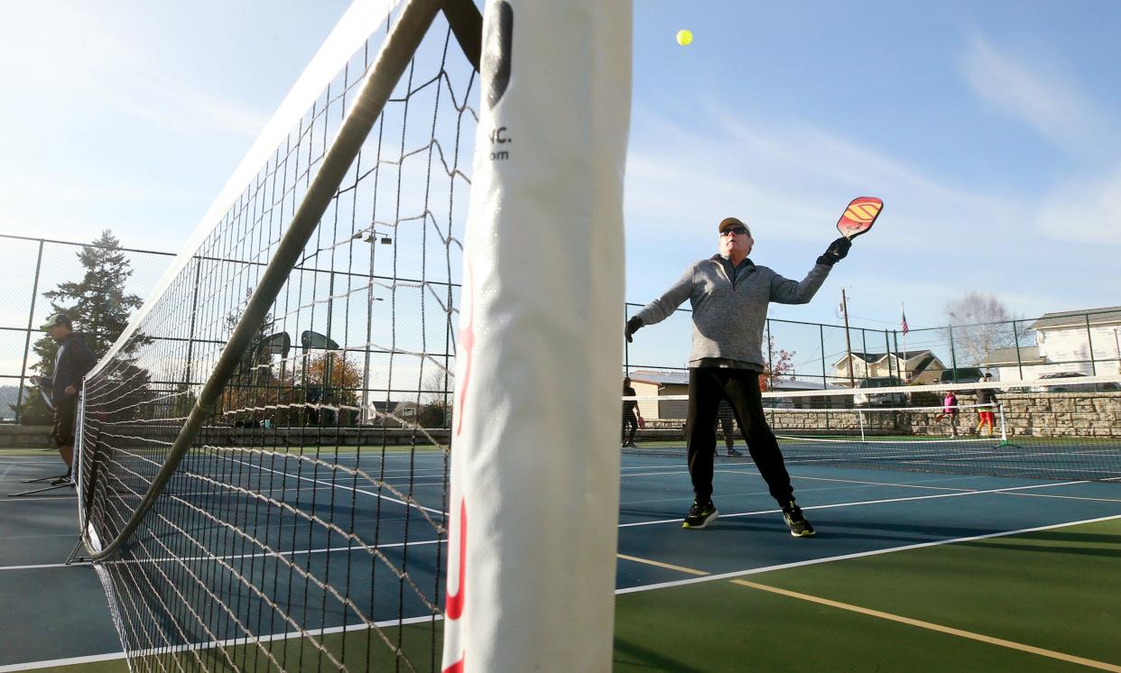 FILE ⁠— Dick O'Brien reaches up to return a shot while playing pickleball in Manette in November 2021.