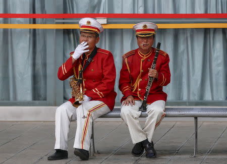 Members of a music band smoke cigarettes on a bench as they take a break, in Kunming, Yunnan province, China, May 27, 2015. REUTERS/Wong Campion