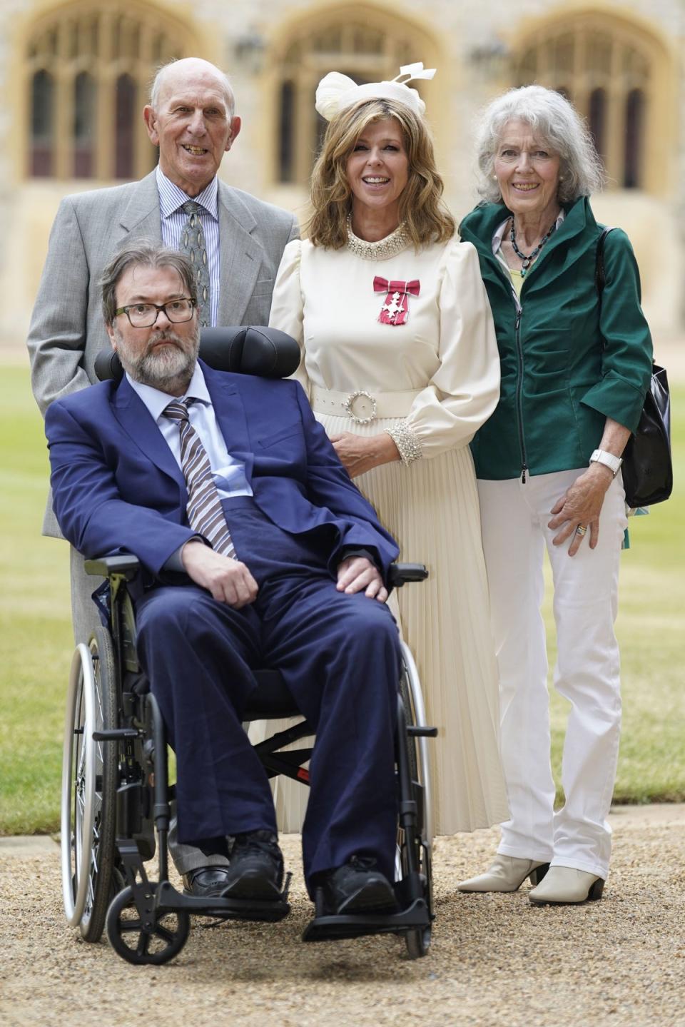 Kate Garraway pictured with her parents and husband Derek Draper as she was awarded an MBE at Windsor Castle in June 2023 (PA)