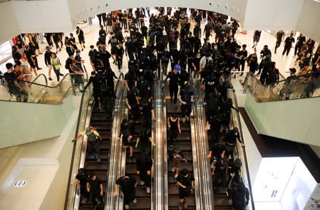 Anti-government protesters ride escalators during a demonstration at New Town Plaza shopping mall in Hong Kong
