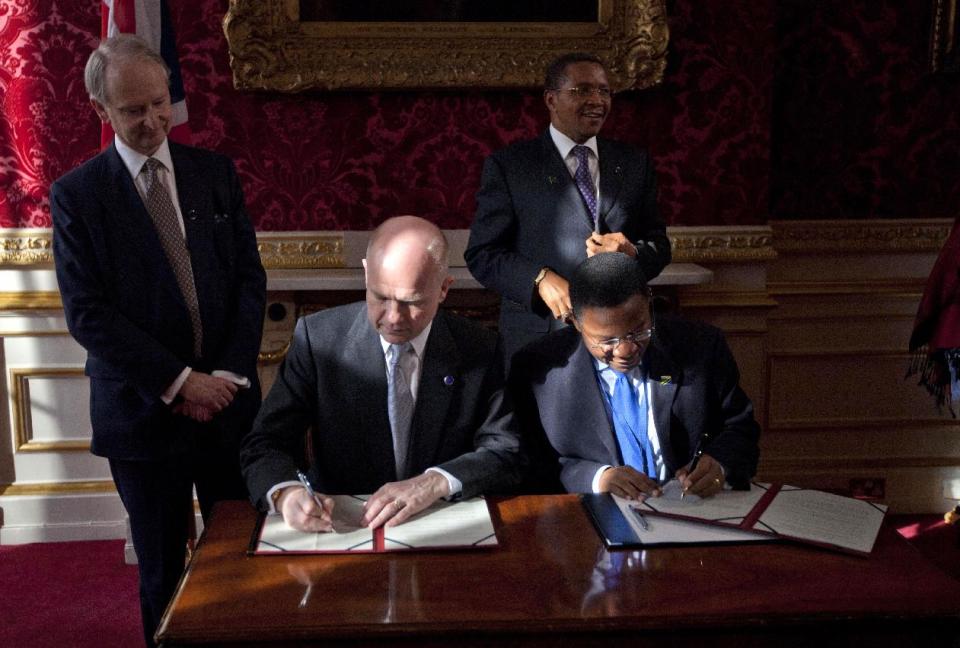 Britain's Foreign Secretary William Hague, seated left, and Tanzania's Minister for Foreign Affairs and International Co-operation Bernard Membe, seated right, sign a treaty on dealing with piracy off the coast of Somalia, watched by Tanzania's President Jakaya Kikwete, standing right, and Britain's Under-Secretary of State at the Foreign and Commonwealth Office Henry Bellingham, standing left, during the London Conference on Somalia at Lancaster House in London, Thursday, Feb. 23, 2012. Nations must help Somalia's fragile leadership tackle terrorism, piracy and hunger or be prepared to pay the price, Britain's leader warned Thursday at an international conference on the troubled east African nation's future. About 50 nations and international organizations attended a one-day summit hosted by Prime Minister David Cameron in London, including Somalia's Western-backed transitional government, U.S. Secretary of State Hillary Rodham Clinton and United Nations Secretary-General Ban Ki-moon. (AP Photo/Matt Dunham-Pool)