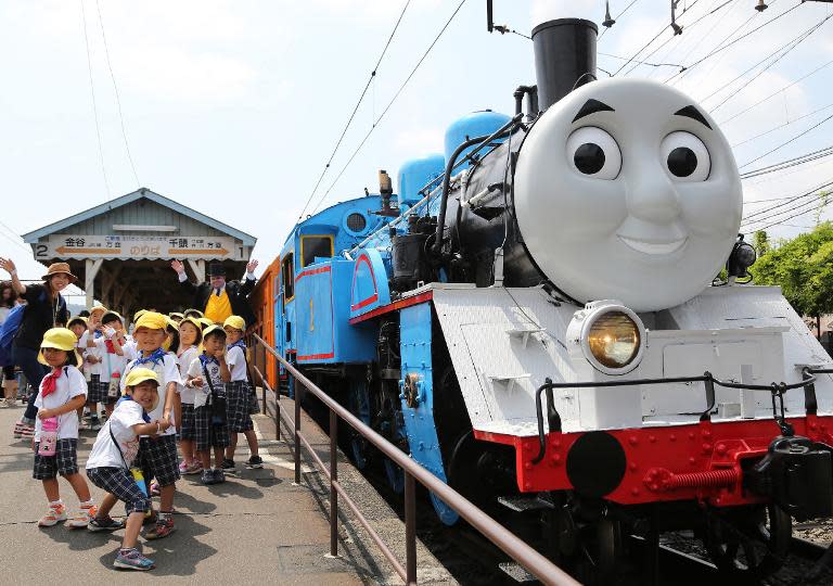 This picture taken on July 2, 2014 shows a life-sized Thomas the Tank Engine, surrounded by young schoolchildren at Shinkanaya station along Japan's Oigawa railway, in the city of Shimada in Shizuoka prefecture, west of Tokyo