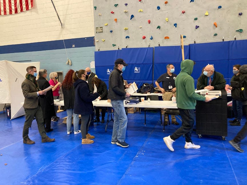 A University of New Hampshire student submits a ballot during the general election at Oyster River High School Tuesday, Nov. 3, 2020.