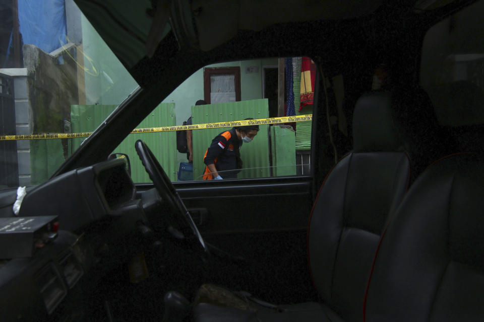 A member of a police forensic squad examines the site where two suspected militants were killed during a raid, in Makassar, South Sulawesi, Indonesia, Wednesday, Jan. 6, 2021. Members of Indonesia's anti-terrorism police squad killed the two suspected militants who they believe were connected to a deadly suicide attack at a Roman Catholic cathedral in the southern Philippines, officials said. (AP Photo/Masyudi S. Firmansyah)