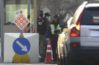 In this Thursday, Feb. 20, 2020, photo, a U.S. military policeman and South Korean security persons U.S. Army base Camp Walker, in Daegu, South Korea. The U.S. and South Korean militaries, used to being on guard for threats from North Korea, face a new and formidable enemy that could hurt battle readiness: a virus spreading around the world that has infected more than 1,200 people in South Korea. (Kim Hyun-tae/Yonhap via AP)