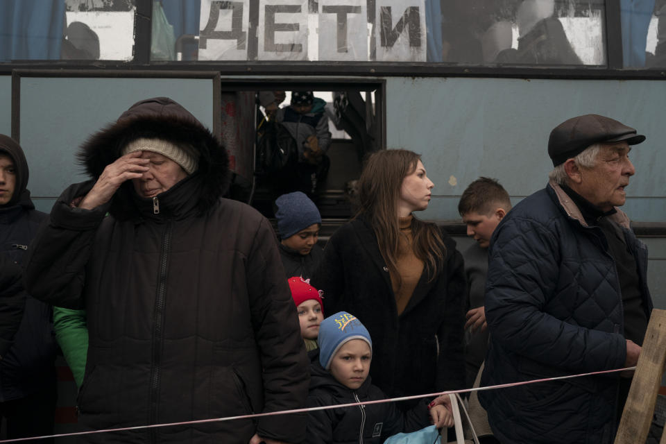 People from Mariupol and nearby towns step out a bus, with a sign on the window that reads in Russian: "Children", and arrive at a refugee center fleeing from the war, in Zaporizhzhia, Ukraine, Thursday, April 21, 2022. Mariupol, which is part of the industrial region in eastern Ukraine known as the Donbas, has been a key Russian objective since the Feb. 24 invasion began. (AP Photo/Leo Correa)