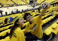 Wenli Xu, left, and Ziang Wang take a photo of themselves before an opening-round NBA basketball playoff series between the Indiana Pacers and the Atlanta Hawks, Saturday, April 19, 2014, in Indianapolis. (AP Photo/Darron Cummings)