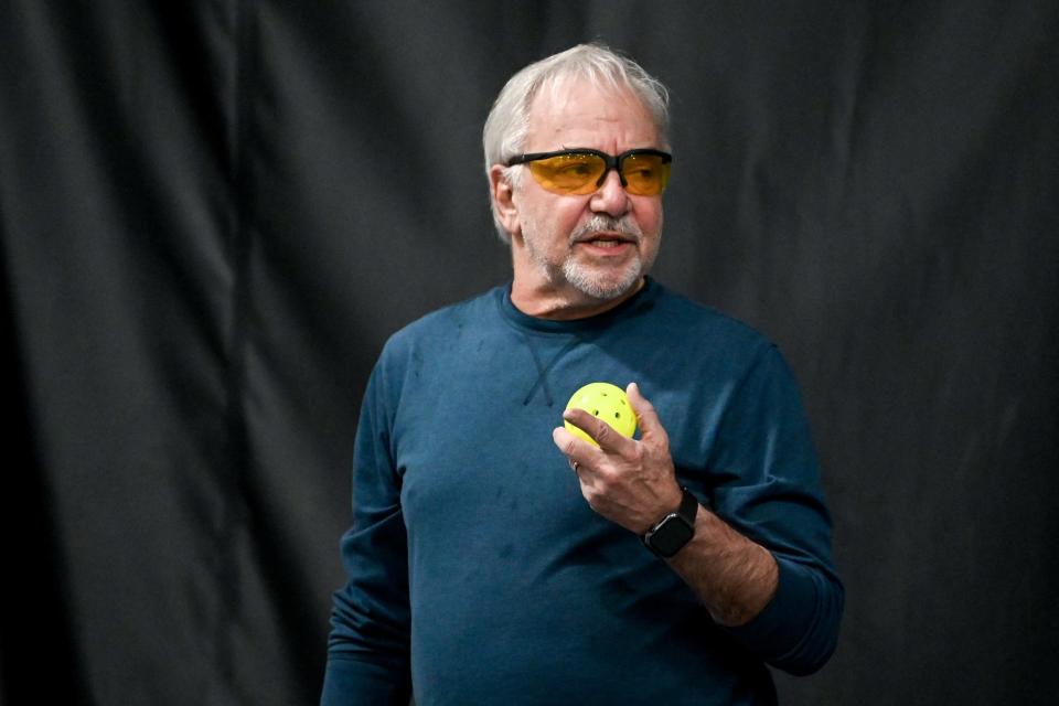 Mike Shore holds a pickleball before serving during a game on Friday, Jan. 27, 2023, at Court One Athletic Clubs in Lansing.