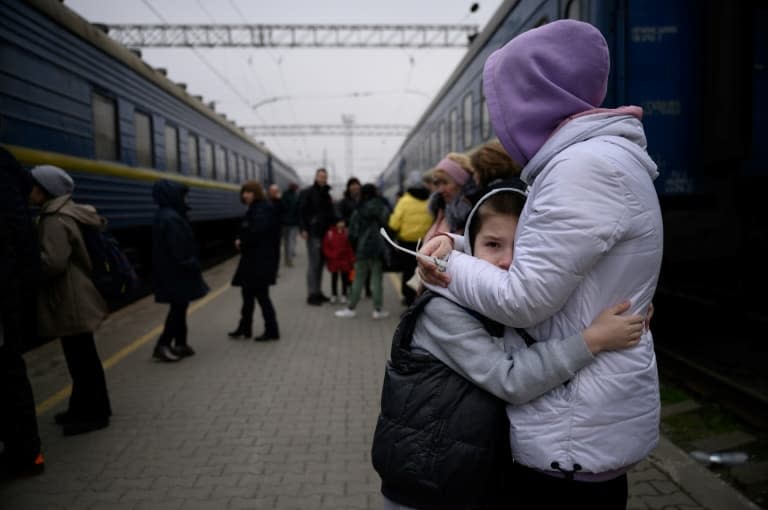 Une femme étreint un enfant avant le départ d'un train de la gare de Zaporijia dans le sud de l'Ukraine le 17 avril 2022 - Ed JONES © 2019 AFP