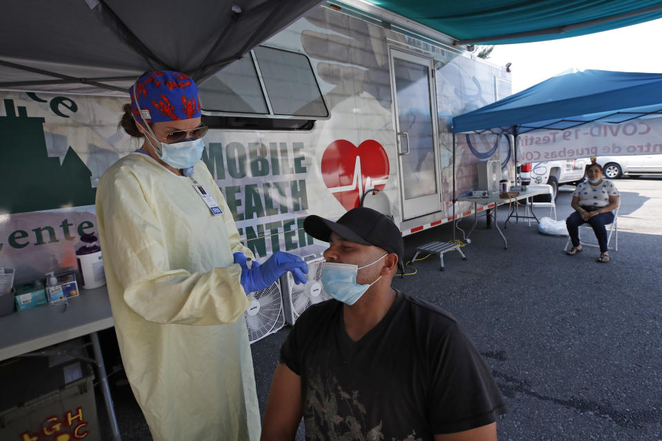 Nurse Tanya Markos administers a coronavirus test on patient Juan Ozoria at a mobile COVID-19 testing unit, Thursday, July 2, 2020, in Lawrence, Mass. (AP Photo/Elise Amendola)