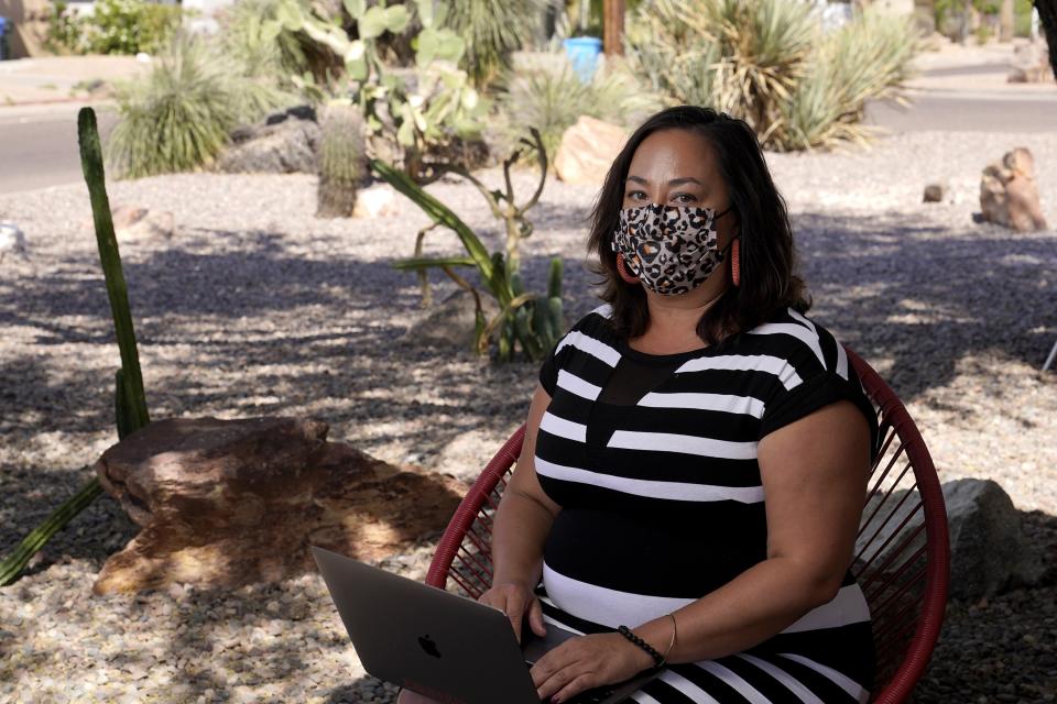 Lisa Phillips at her home Tuesday, April 20, 2021, in Phoenix. When the anniversary of the pandemic arrived, Phillips was not eager for a trip down memory lane. The Phoenix woman had developed symptoms and quarantined with a suspected case of COVID-19 last spring, lost her mother to the disease in July, and been hospitalized herself in November, overwhelmed by grief and isolation. (AP Photo/Ross D. Franklin)